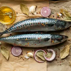 Två hela makrillar med kryddor, lökringar, vitlök och olja. Makrill nyttigt och gott att tillaga!
