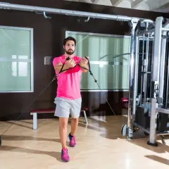 Man tränar bröstmusklerna med en flyes maskin i ett modernt gym.