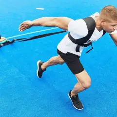 Man drar en släde på blått underlag, en övning som visar hur man hittar motivation genom fysisk ansträngning.