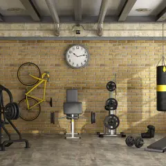 Ett komplett hemmagym med vikter, boxningssäck, cykel och träningsbänk. Perfekt för att bygga hemmagym i industriell stil.