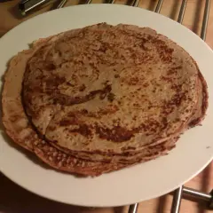 Stack of protein pancakes on a white plate.