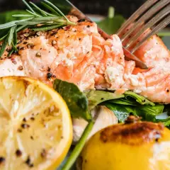 En saftig bit lax i ugnen, perfekt tillagad med citron, rosmarin och körsbärstomater.