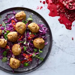 Falafel i airfryer serveras på en bädd av rödkål med strimlad paprika och granatäpple.