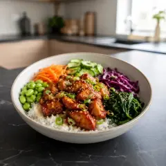 En skål med ris, kyckling, edamame, morötter, gurka, rödkål och spenat. Perfekt för deff matlådor.