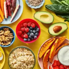En färgsprakande dukning med proteinrik vegetarisk mat: bönor, ägg, nötter, bär, grönsaker och quinoa.