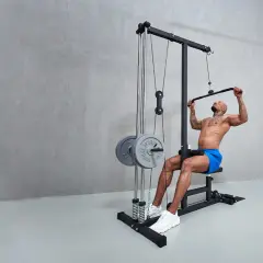 Man tränar latsdrag muskler på ett gym. Han sitter på en bänk och drar ner en stång med vikter.