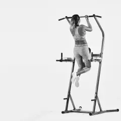 Kvinna tränar pull-ups och bygger starka chins muskler på ett träningsställ.