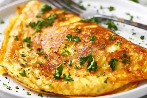 En gyllene, fluffig omelett toppad med färsk persilja. En perfekt och nyttig omelett för en snabb frukost eller lunch.