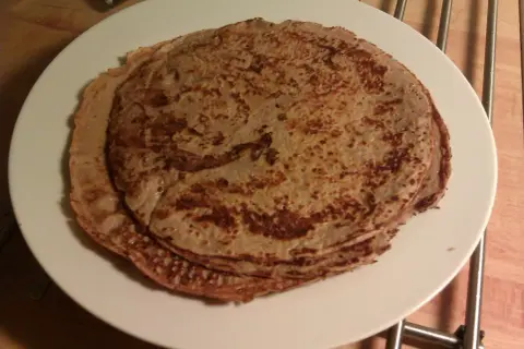 En hög med tunna pannkakor på en vit tallrik. Perfekt protein frukost för att gå ner i vikt.