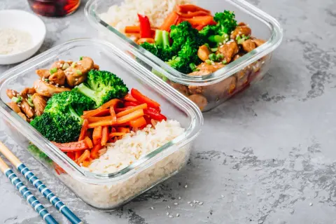 Två matlådor med ris, kyckling, broccoli och paprika. Perfekt för ett proteinrikt matlåda recept.