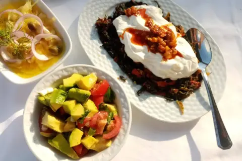 En härlig medelhavskost frukost med avokadosallad, en rätt med yoghurt och grönsaker samt en sallad med lök och kapris.