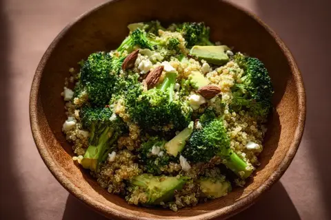 En skål med quinoa, broccoli, avokado och mandlar. En hälsosam och nyttig måltid.