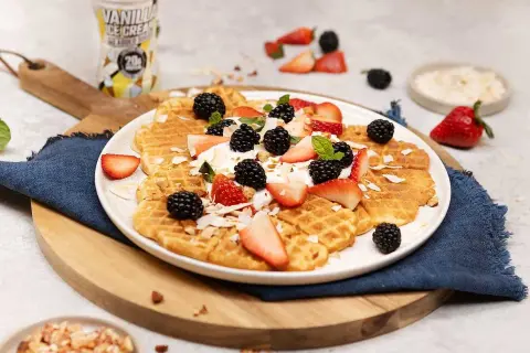 Ljuvliga protein våfflor toppade med färska bär, grädde och kokosflingor. En perfekt start på dagen!