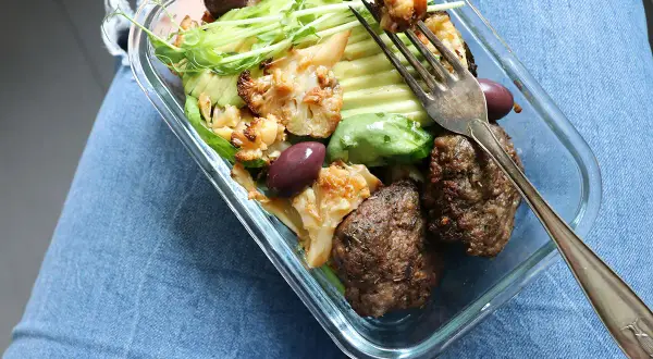En kall matlåda med köttbullar, blomkål, avokado och oliver. Perfekt för en snabb lunch.
