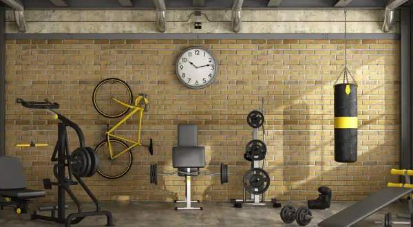 Ett komplett hemmagym med vikter, boxningssäck, cykel och träningsbänk. Perfekt för att bygga hemmagym i industriell stil.