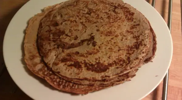 Stack of protein pancakes on a white plate.