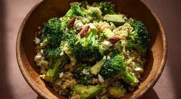 En skål med quinoa, broccoli, avokado och mandlar. En hälsosam och nyttig måltid.