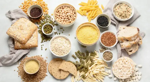 En variation av kolhydrater mat: bröd, pasta, ris, havre, linser, kikärtor och majs.