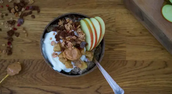 En skål med chiapudding och kvarg, toppad med granola, äpple och jordnötssmör. En perfekt frukost!