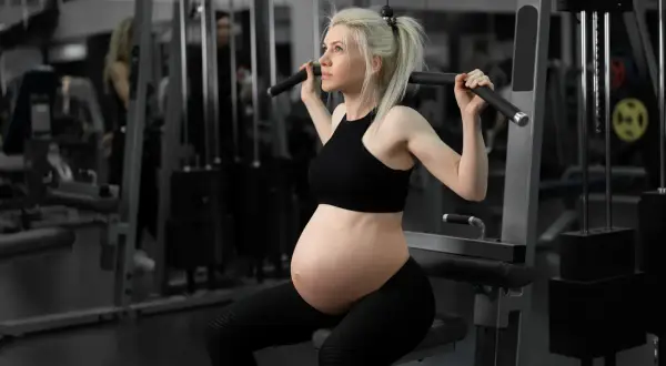 Gravid kvinna tränar marklyft på gym.