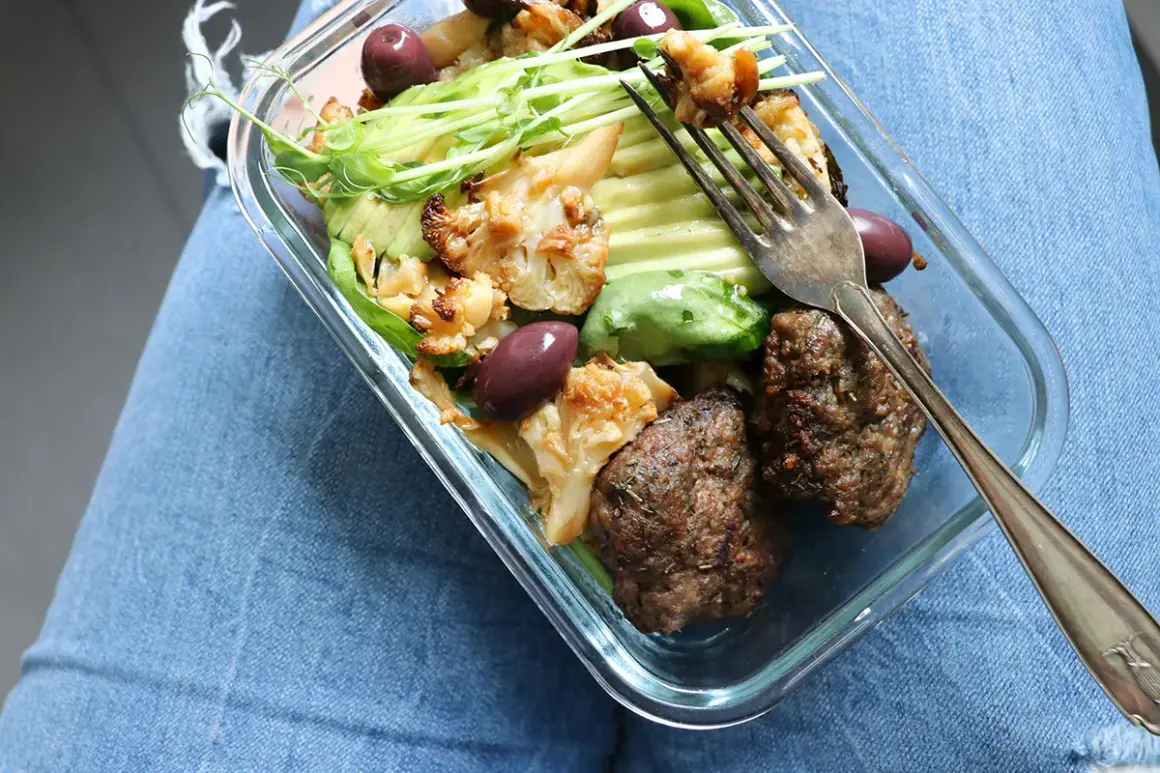 En kall matlåda med köttbullar, blomkål, avokado och oliver. Perfekt för en snabb lunch.