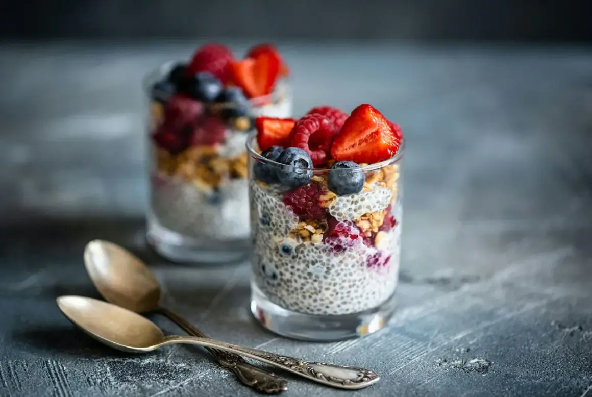 Två glas med chiapudding, toppad med bär och granola. Perfekt för en hälsosam frukost med koll på chiapudding kalorier.