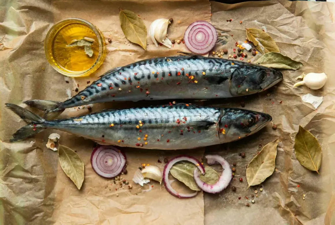 Två hela makrillar med kryddor, lökringar, vitlök och olja. Makrill nyttigt och gott att tillaga!