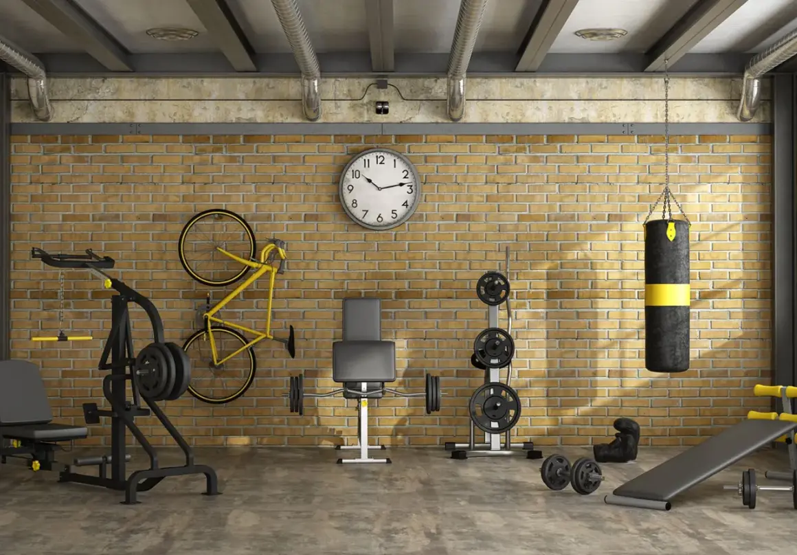Ett komplett hemmagym med vikter, boxningssäck, cykel och träningsbänk. Perfekt för att bygga hemmagym i industriell stil.