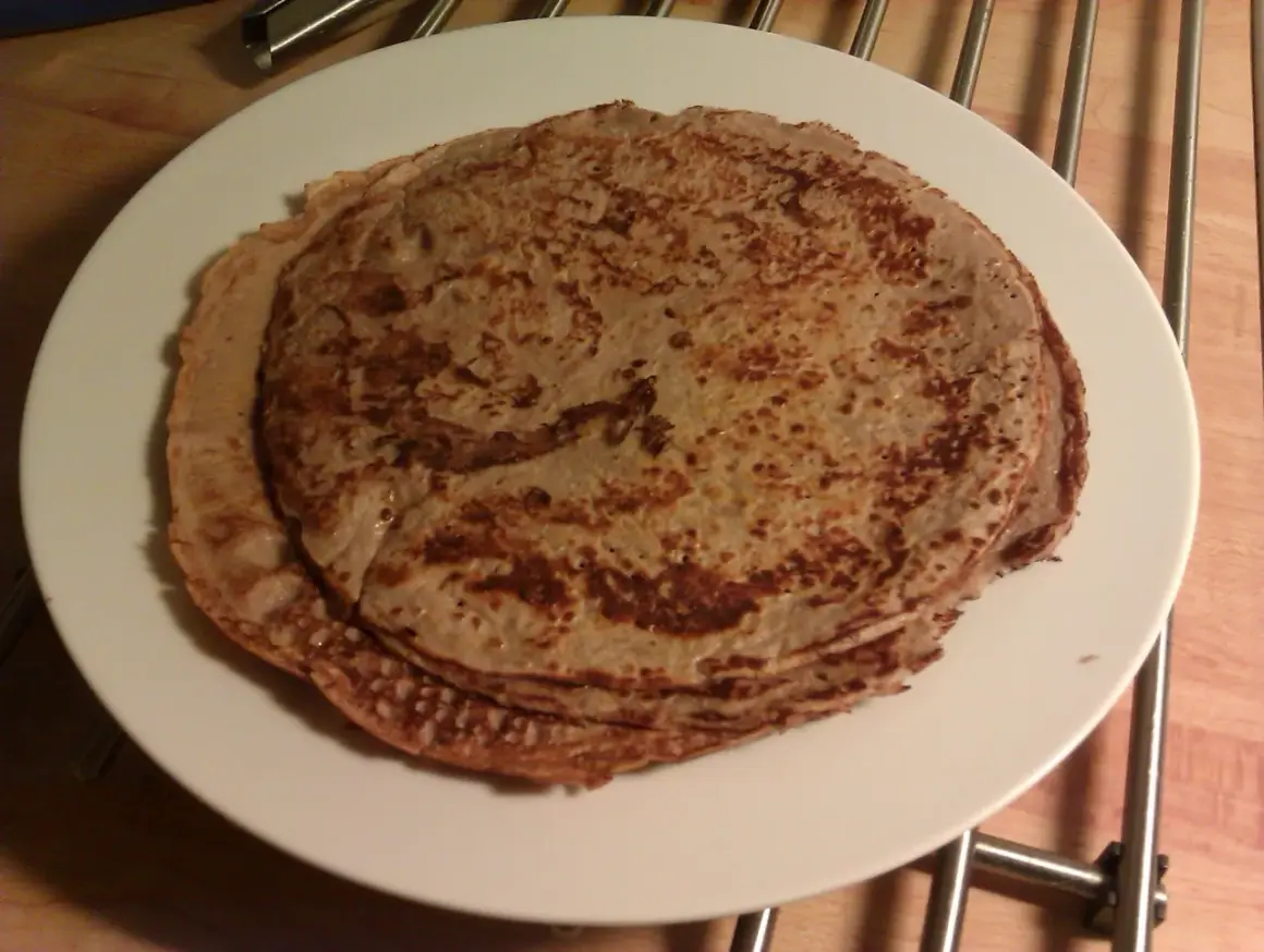 Stack of protein pancakes on a white plate.