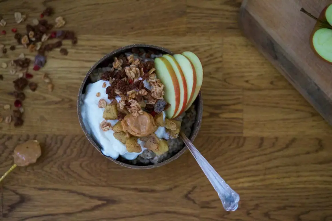 En skål med chiapudding och kvarg, toppad med granola, äpple och jordnötssmör. En perfekt frukost!