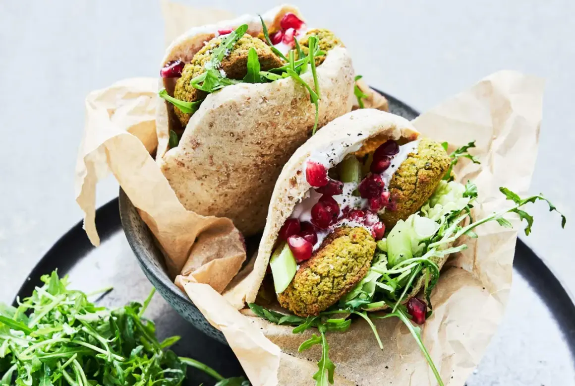 Två läckra pitabröd fyllda med ugnsbakad falafel, färska grönsaker, krämig sås och granatäppelkärnor.