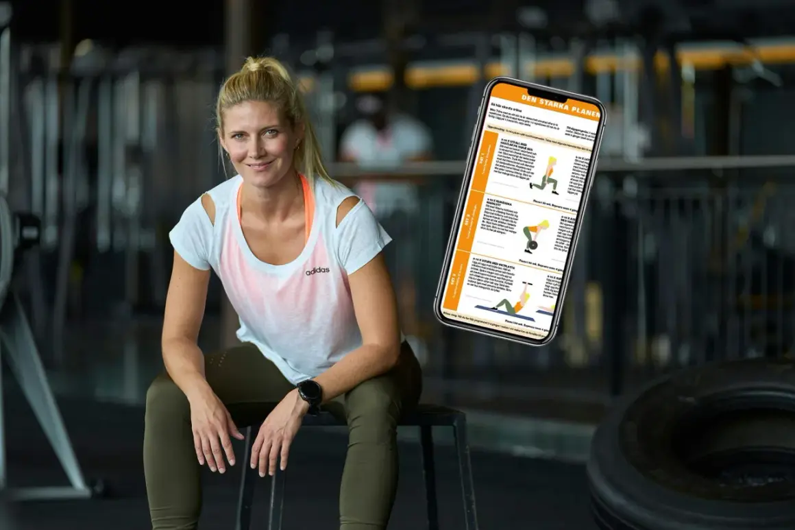 En kvinna sitter i ett gym med en telefon som visar en träningsplan. Hon ser ut att veta hur man blir stark.