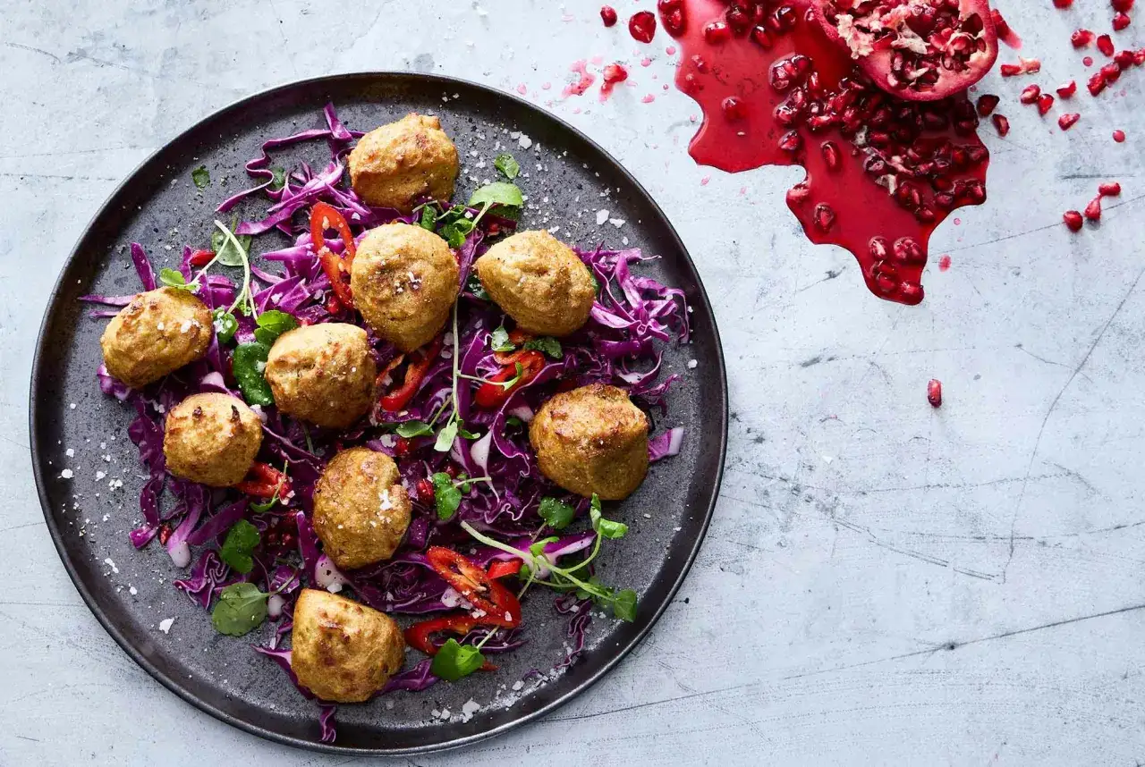 Falafel i airfryer serveras på en bädd av rödkål med chili och granatäpple.