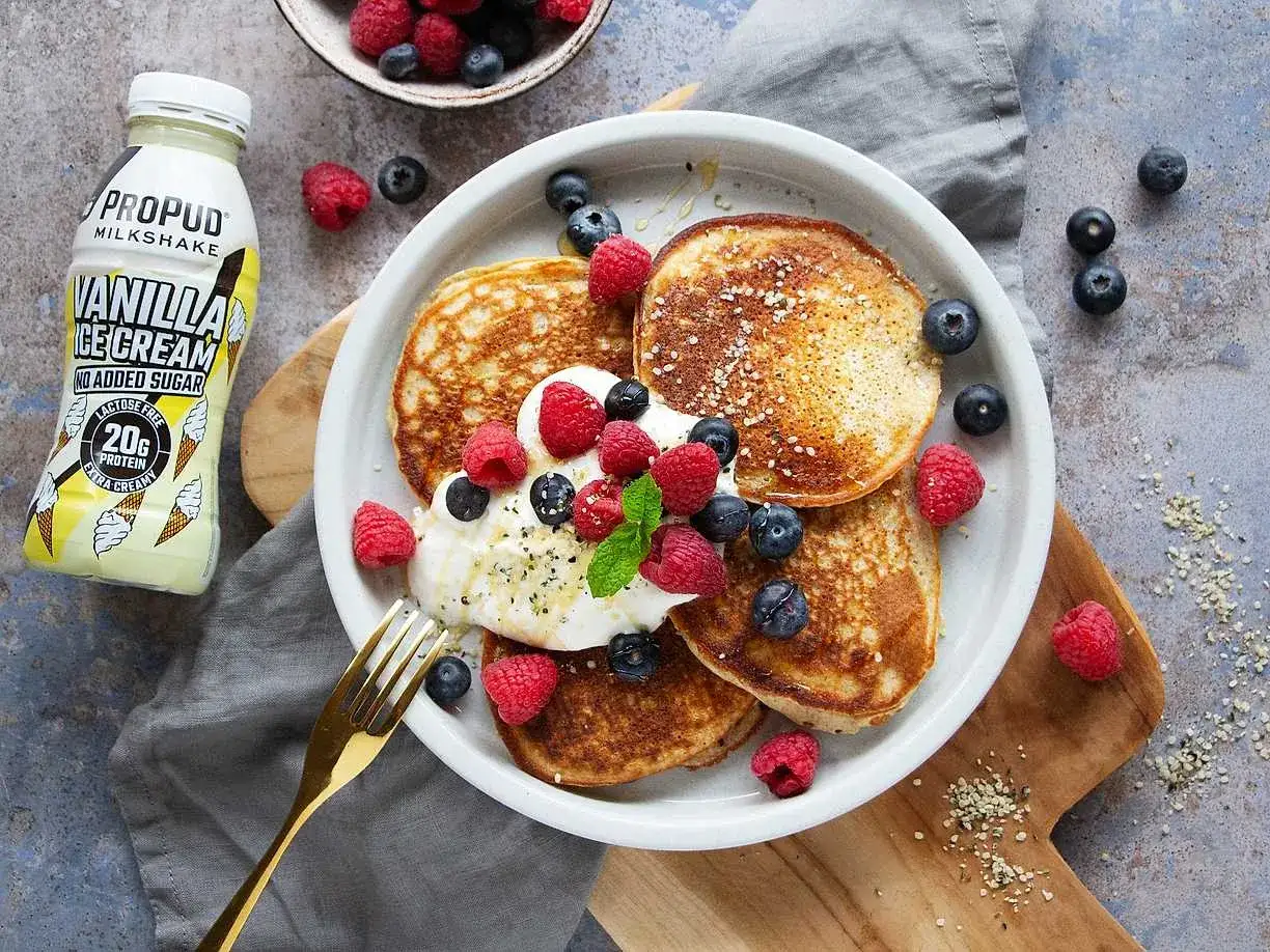 Proteinpannkakor recept med f&auml;rska b&auml;r och en flaska vanilj milkshake.